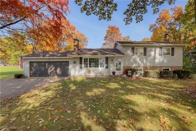 Split level home with a garage and a front lawn | Image 1