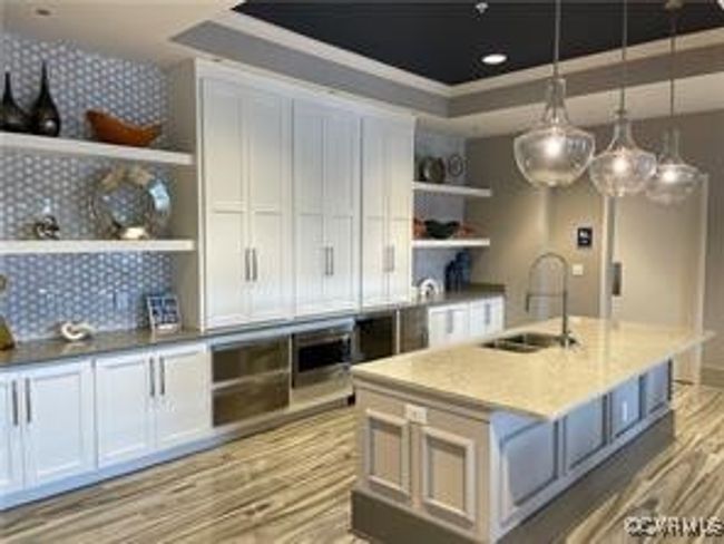 Kitchen featuring backsplash, open shelves, a tray ceiling, light wood finished floors, and a sink | Image 14