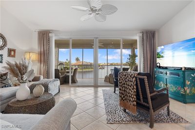 Living room with a wealth of natural light, light tile patterned floors, and ceiling fan | Image 3