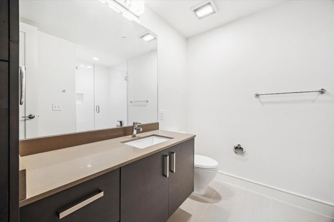 Bathroom featuring vanity, toilet, a stall shower, baseboards, and tile patterned floors | Image 12