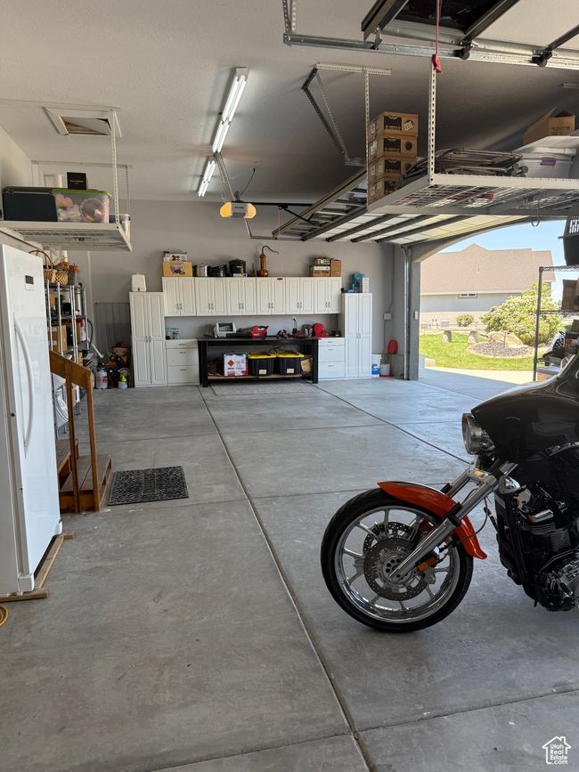 Garage with freestanding refrigerator and a garage door opener | Image 98