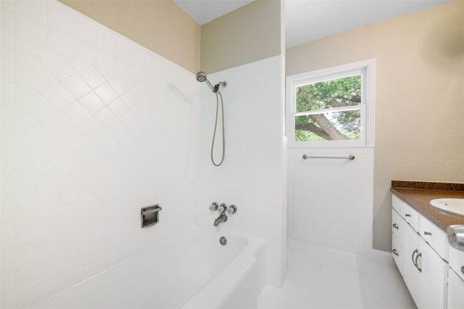 Bathroom featuring vanity and washtub / shower combination | Image 22