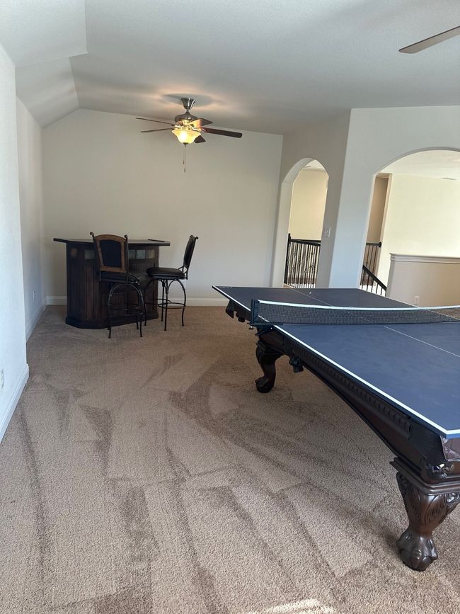 Rec room featuring carpet, vaulted ceiling, ceiling fan, and baseboards | Image 25