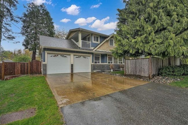 Craftsman-style home featuring stone siding, a garage, fence, and concrete driveway | Image 27