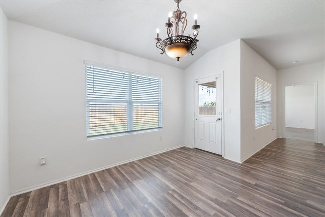Unfurnished dining area with a chandelier and wood finished floors | Image 9