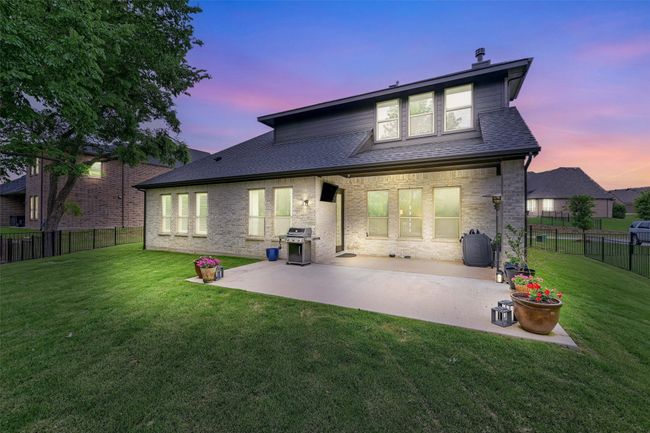 Rear view of property featuring a fenced backyard, a patio area, a shingled roof, and a lawn | Image 39