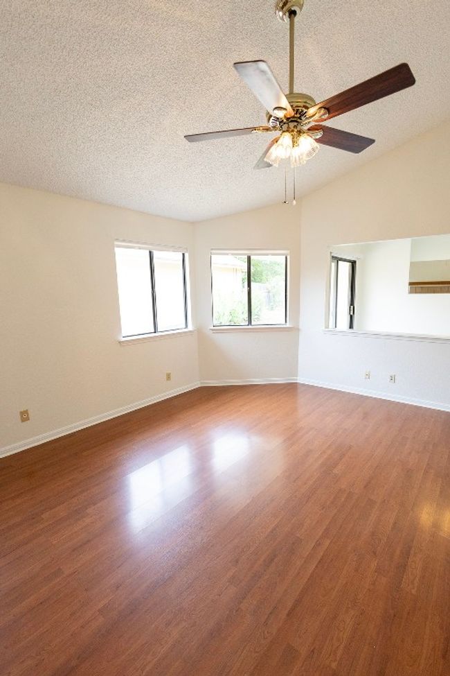 Spare room with a textured ceiling, a ceiling fan, wood finished floors, and baseboards | Image 12