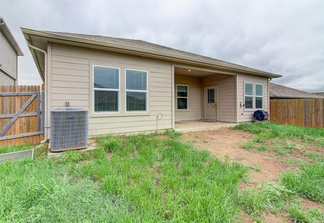 Rear view of house with a patio, cooling unit, and fence | Image 27