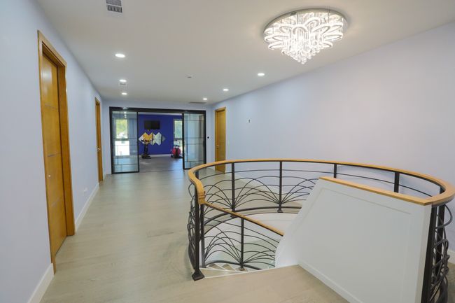 Corridor with a notable chandelier and wood-type flooring | Image 18