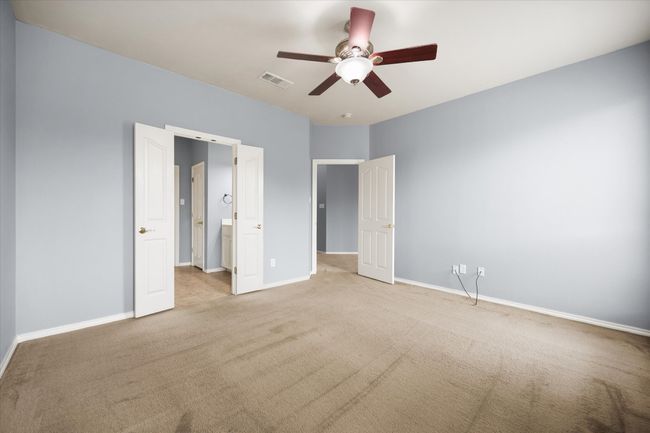 Unfurnished bedroom featuring carpet, ceiling fan, and ensuite bathroom | Image 14