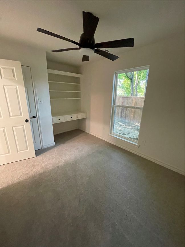 Secondary bedroom with baseboards, carpet floors, and ceiling fan and Built In Desk | Image 12