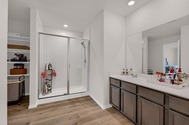 Ensuite bathroom featuring a stall shower, vanity, wood finished floors, and recessed lighting | Image 20
