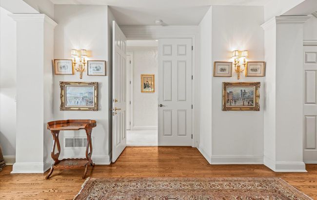 Hallway featuring wood finished floors, baseboards, and a chandelier | Image 20