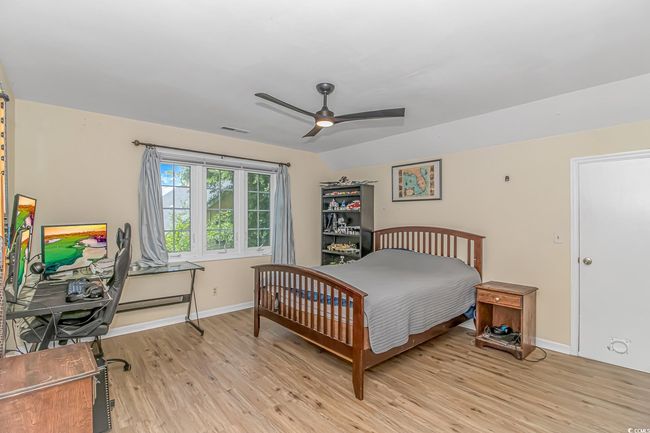 Bedroom with light wood finished floors, a baseboard heating unit, and ceiling fan | Image 20