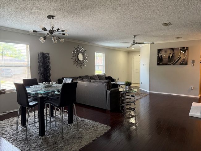 Dining room with ornamental molding, a chandelier, dark wood-type flooring, a textured ceiling, and a ceiling​​‌​​​​‌​​‌‌​‌‌​​​‌‌​​‌‌​‌​​​​​‌ fan | Image 21