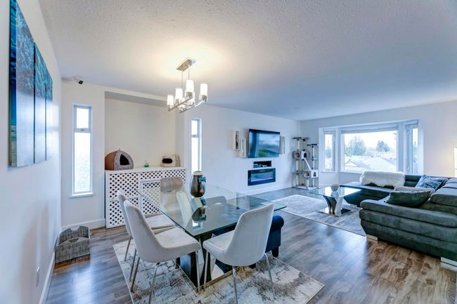 Dining space featuring an inviting chandelier, baseboards, wood finished floors, and a textured ceiling | Image 5