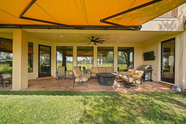 The first floor covered patio with access from the breakfast room and private access from the owner's suite includes recessed lighting, a ceiling fan with light fixture, pre-wiring for a wall mounted flat screen TV & Saltillo tile flooring. | Image 49
