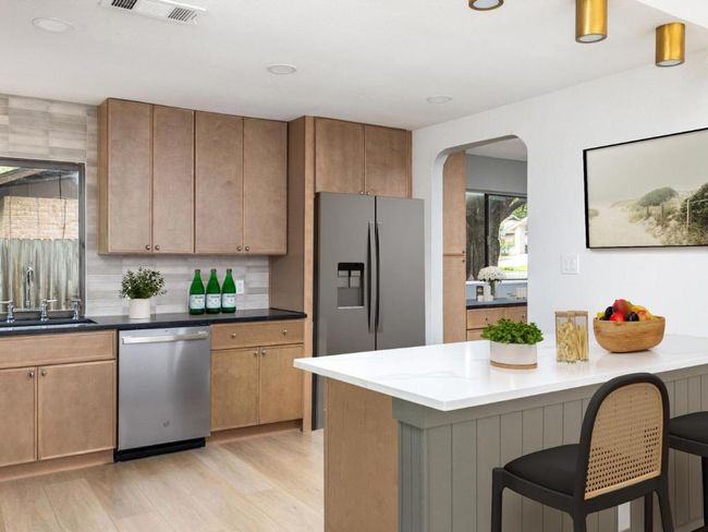 Kitchen featuring stainless steel appliances, arched walkways, light wood-style floors, a kitchen bar, and recessed lighting | Image 13