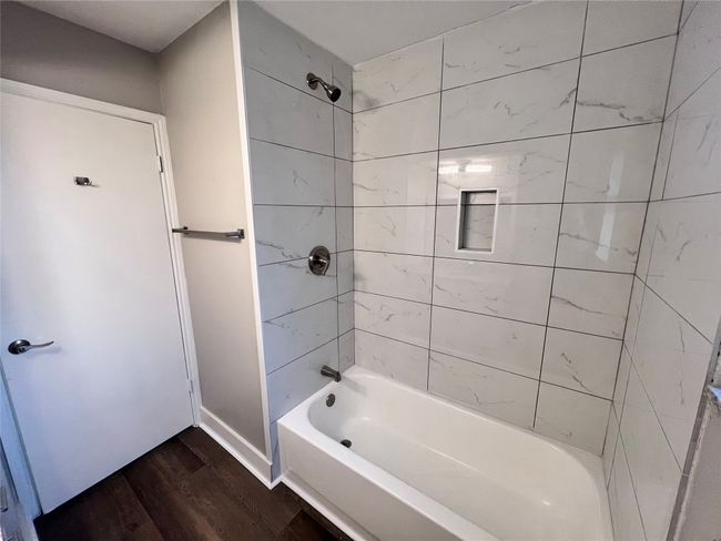 Bathroom with hardwood / wood-style floors and tiled shower / bath combo | Image 17