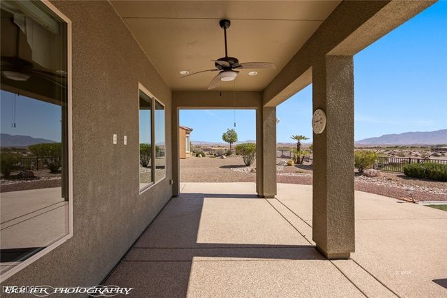 View of patio featuring a mountain view, ceiling fan, and fence | Image 52