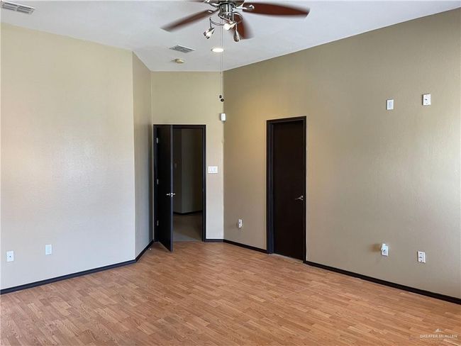 Unfurnished room featuring a ceiling fan, light wood finished floors, and baseboards | Image 13
