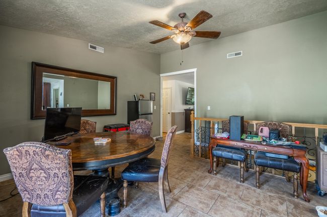 Dining room featuring ceiling fan, a textured ceiling, light tile patterned flooring, and an office area | Image 21