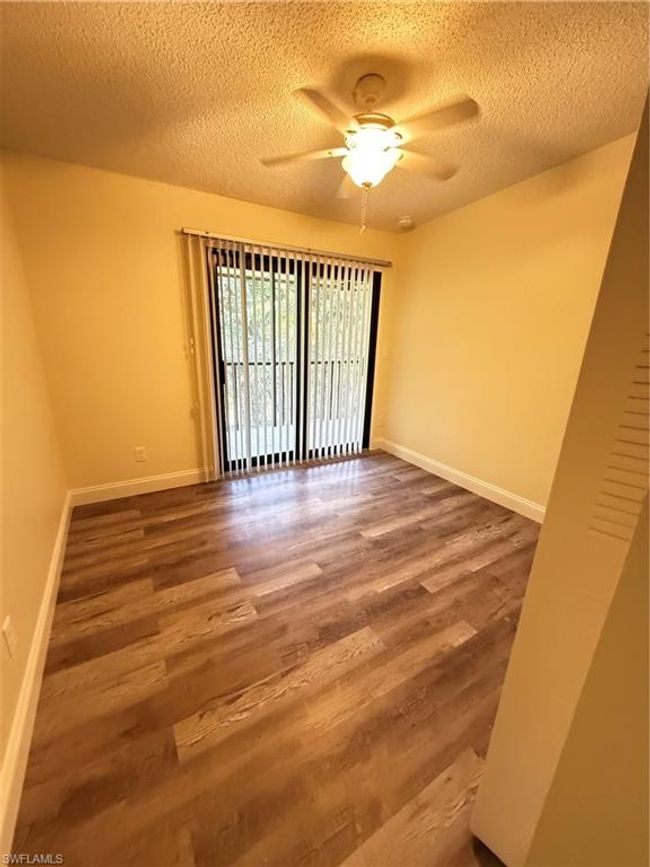 Spare room with baseboards, a ceiling fan, wood finished floors, and a textured ceiling | Image 9