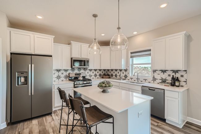Photo is of the model. Enjoy plenty of seating at the kitchen island and dining area adjacent to the kitchen. Perfect for entertaining or having a family meal together. | Image 5