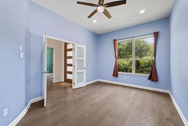 Empty room featuring ceiling fan, dark wood-style flooring, french doors, and recessed lighting | Image 22