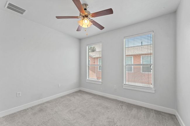 Unfurnished room with light colored carpet and a ceiling fan | Image 7