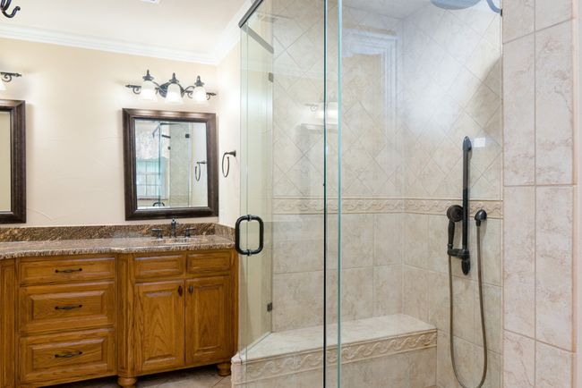 Bathroom featuring crown molding, vanity, and a shower stall | Image 33