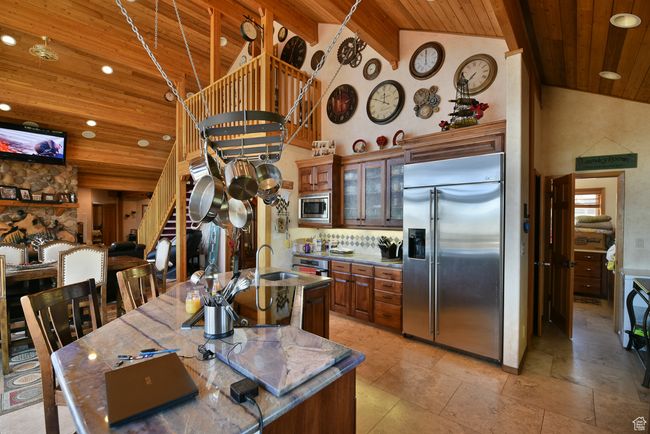 Kitchen featuring recessed lighting, built in appliances, wooden ceiling, glass insert cabinets, and high vaulted ceiling | Image 74