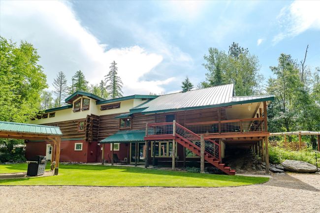 Back of house featuring stairway, a lawn, a deck, and log siding | Image 14