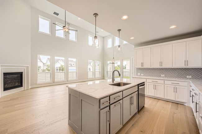 Kitchen with stainless steel dishwasher, gray cabinetry, recessed lighting, decorative backsplash, and light stone counters | Image 10