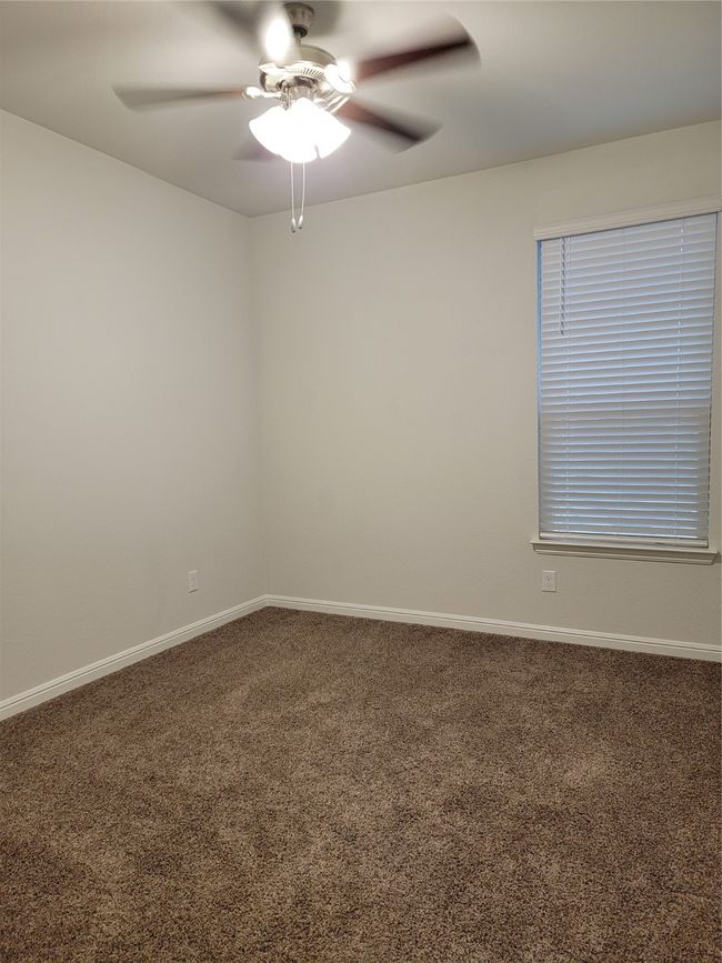 Carpeted empty room featuring a ceiling fan and baseboards | Image 18