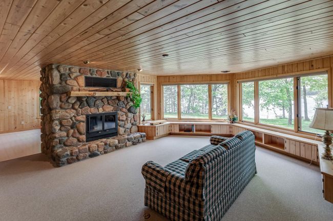 Look at this lower level family room with a stunning stone fireplace and lake views! | Image 27
