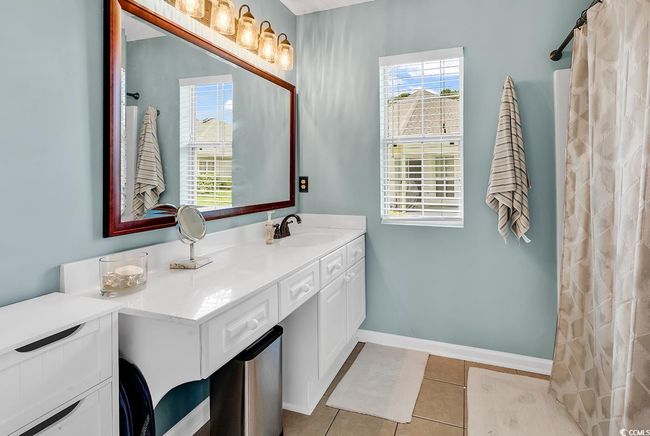 Full bathroom with vanity, tile patterned flooring, and a shower with shower curtain | Image 28