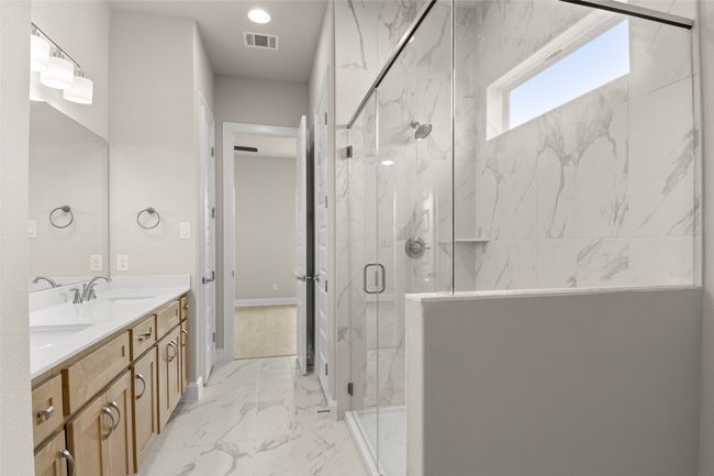 Full bathroom with marble finish floors, double vanity, and a marble finish shower | Image 28