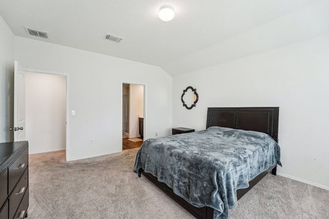 Bedroom with light carpet, visible vents, and vaulted ceiling | Image 18