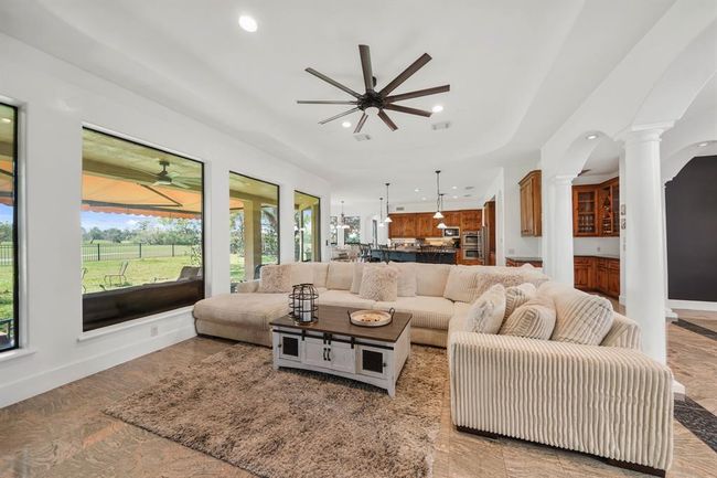 A wall of fixed glass windows overlook the covered patio, wrought iron fenced backyard and has serene views of the golf course. | Image 9
