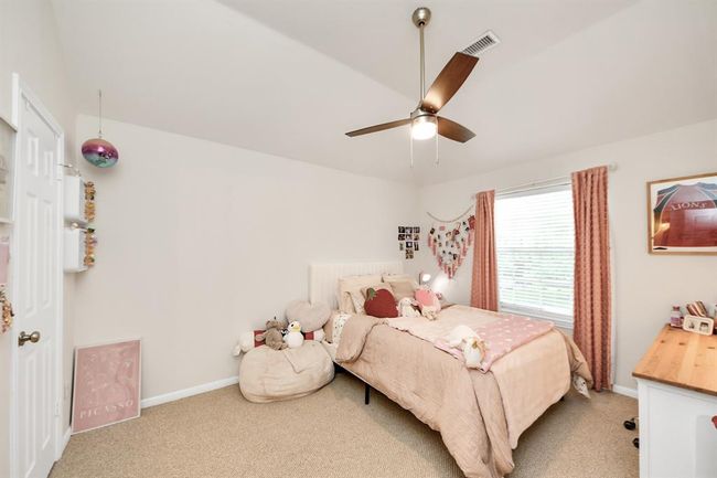 Explore the oversized secondary bedroom located on the second floor, featuring ample space for various furniture arrangements, a large window that invites natural light, and a spacious walk-in closet. | Image 36