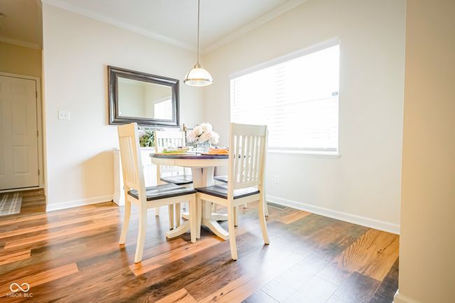 dining room featuring crown molding, wood finished floors, and baseboards | Image 12
