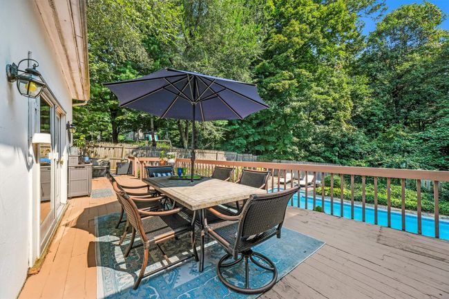 Deck featuring a fenced in pool, outdoor dining area, and fence | Image 40