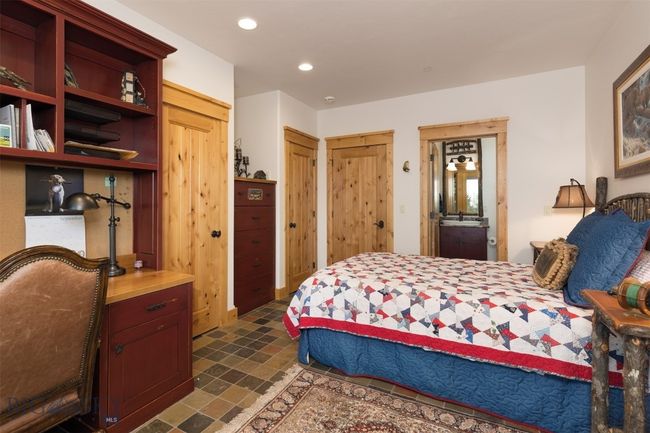 Entry level Bedroom 1 with ensuite bathroom, custom built in dressers, desk and bookshelves. | Image 50