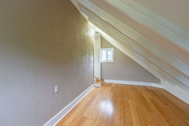 Bonus room with light wood finished floors, vaulted ceiling, and a textured wall | Image 9