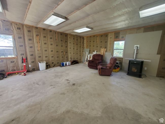 Miscellaneous room featuring a wood stove and unfinished concrete floors | Image 17