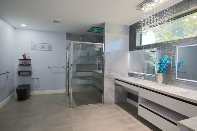 Bathroom featuring vanity, a shower with shower door, and backsplash | Image 12