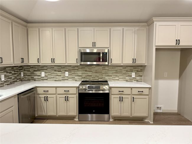 Kitchen with appliances with stainless steel finishes, light countertops, and decorative backsplash | Image 8