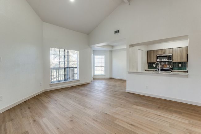 Unfurnished living room with light wood-type flooring, high vaulted ceiling, and beamed ceiling | Image 12
