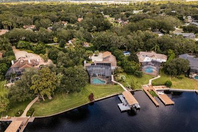 Aerial view of the back of the property featuring the pool, backyard and boat house. | Image 2